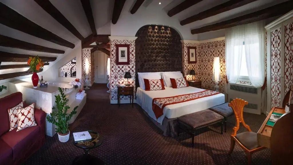 Elegant gestaltetes Schlafzimmer mit rotem Muster und Holzbalken an der Decke