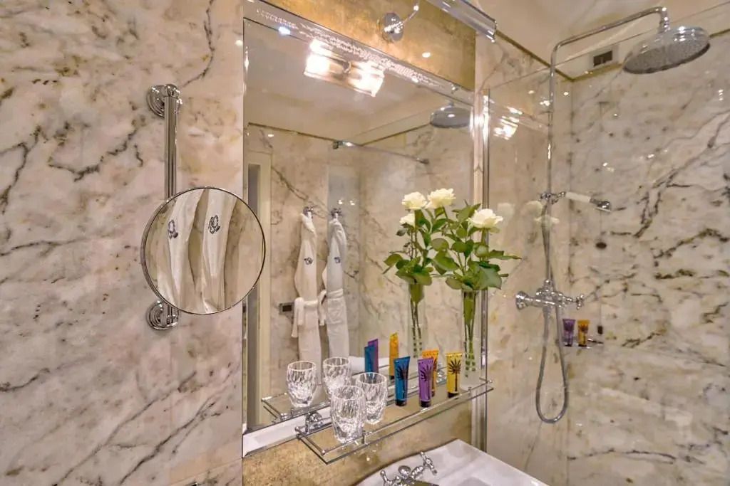 Elegantes Badezimmer mit Marmorverkleidung und luxuriösen Annehmlichkeiten im Londra Palace Venezia