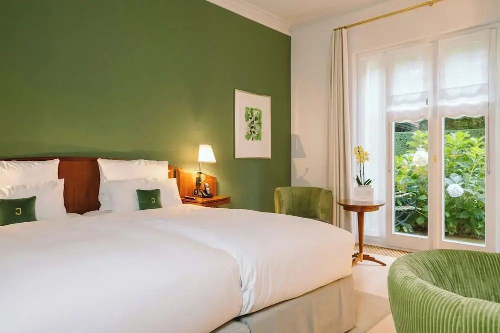 Einladendes Deluxe Doppelzimmer mit grünem Akzent und Gartenblick