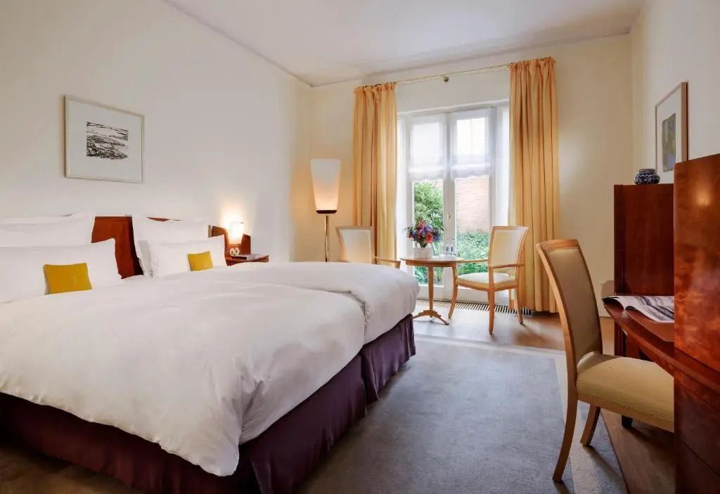 Elegantes Superior Doppelzimmer mit großem Doppelbett und großen Fenstern.