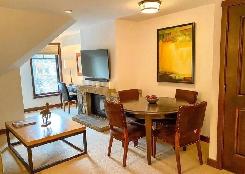Wohnbereich einer Suite mit Esstisch Kamin und Wandkunst