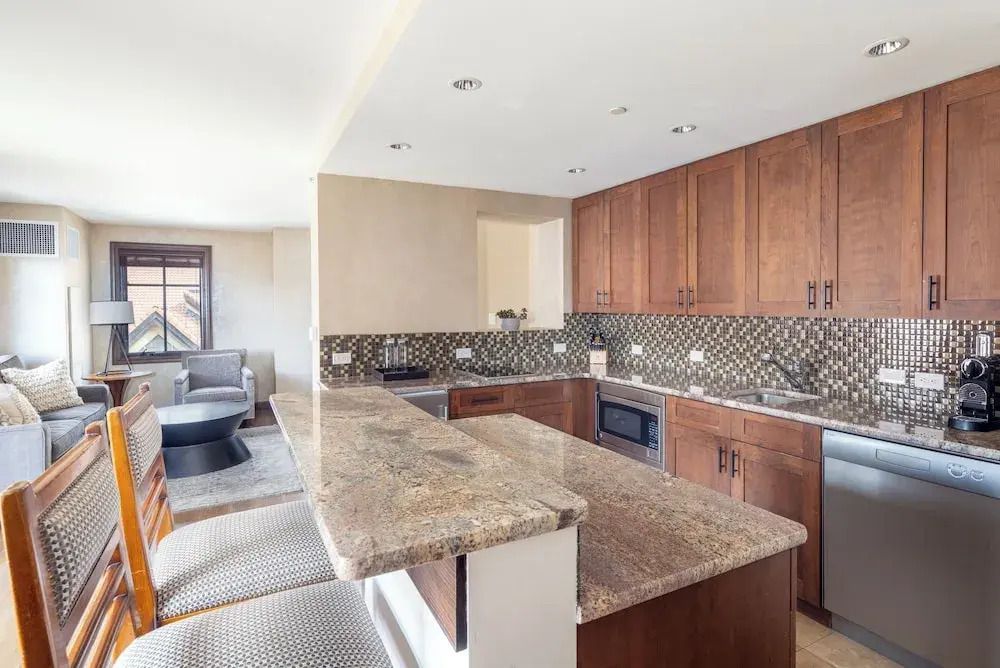 Moderne Küche in einer Suite mit Holzschränken und Granitarbeitsflächen