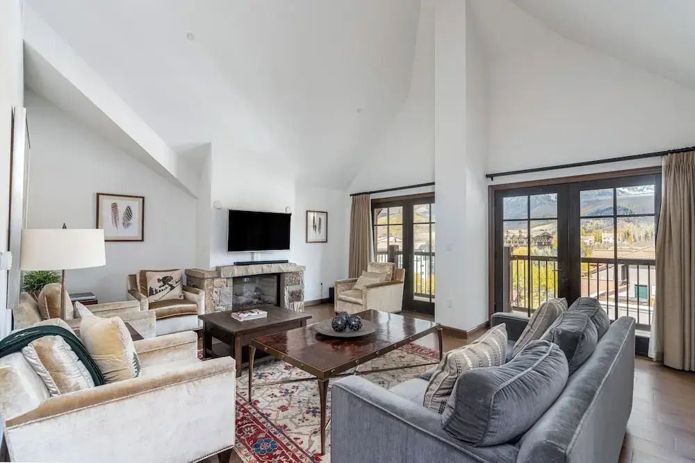 Wohnbereich im Penthouse mit Kamin, bequemen Sofas und Bergblick.