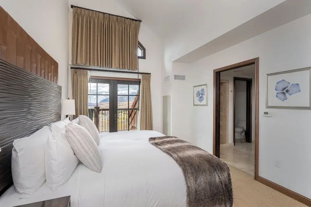 Geräumiges Schlafzimmer mit großen Fenstern und Bergblick.