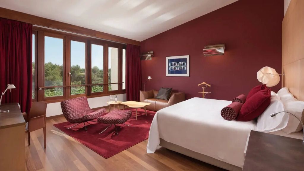 Stylischer Raum mit Doppelbett, moderner Einrichtung und großen Fenstern mit Gartenblick.