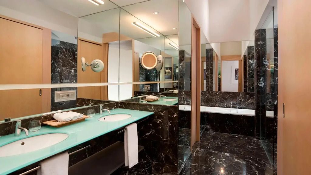 Stilvolles Badezimmer mit Marmordetails und großer Spiegelfläche