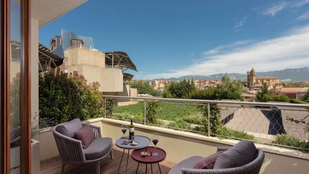 Balkon mit Blick auf die Natur und Weinflaschen auf einem Tisch