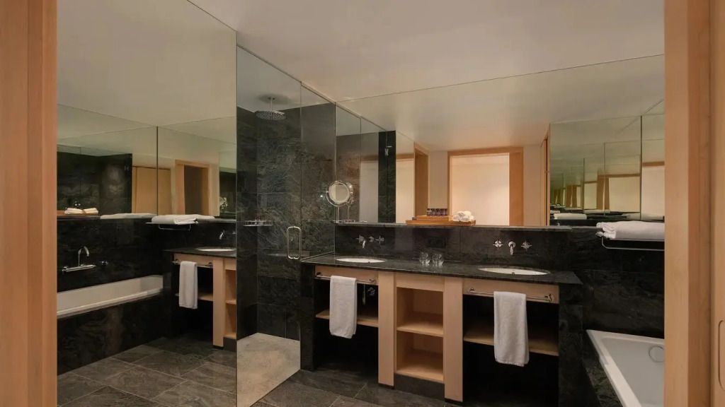 Geräumiges Badezimmer mit moderner Ausstattung und dunklen Fliesen