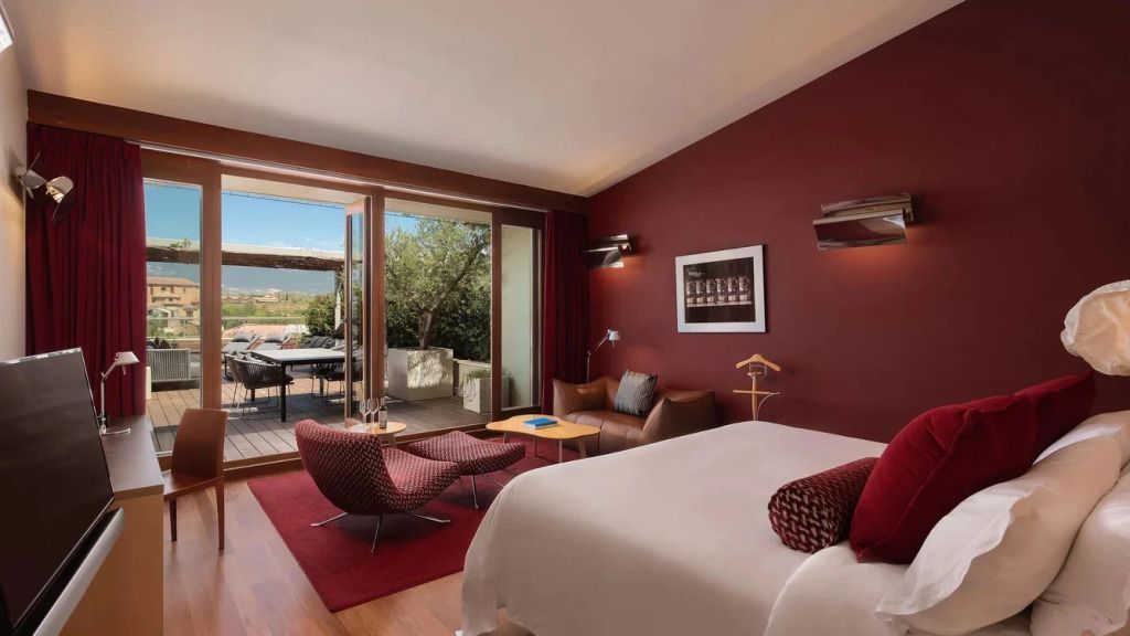Modernes Hotelzimmer mit Doppelbett und Terrasse mit Blick auf die Natur