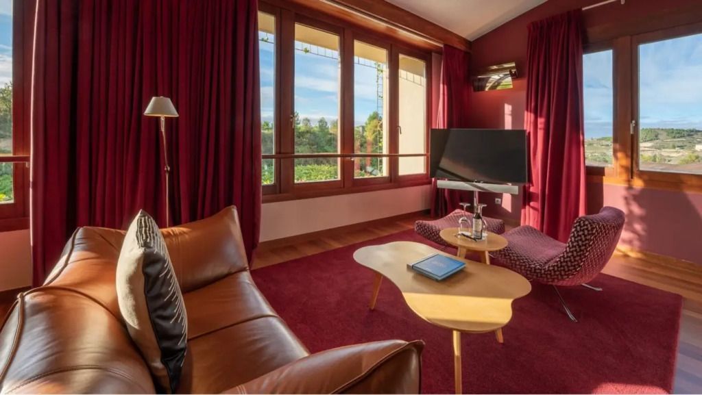 Sitzecke in Suite mit rotem Teppich, Ledersofa und großem Fenster