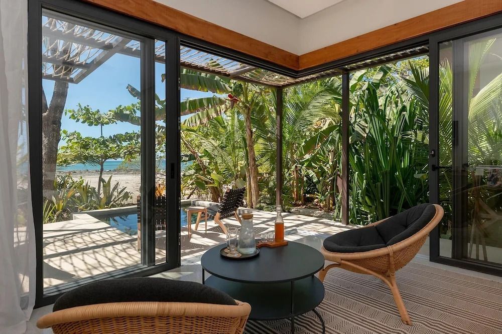 Bungalow mit Blick auf tropische Pflanzen und den Strand