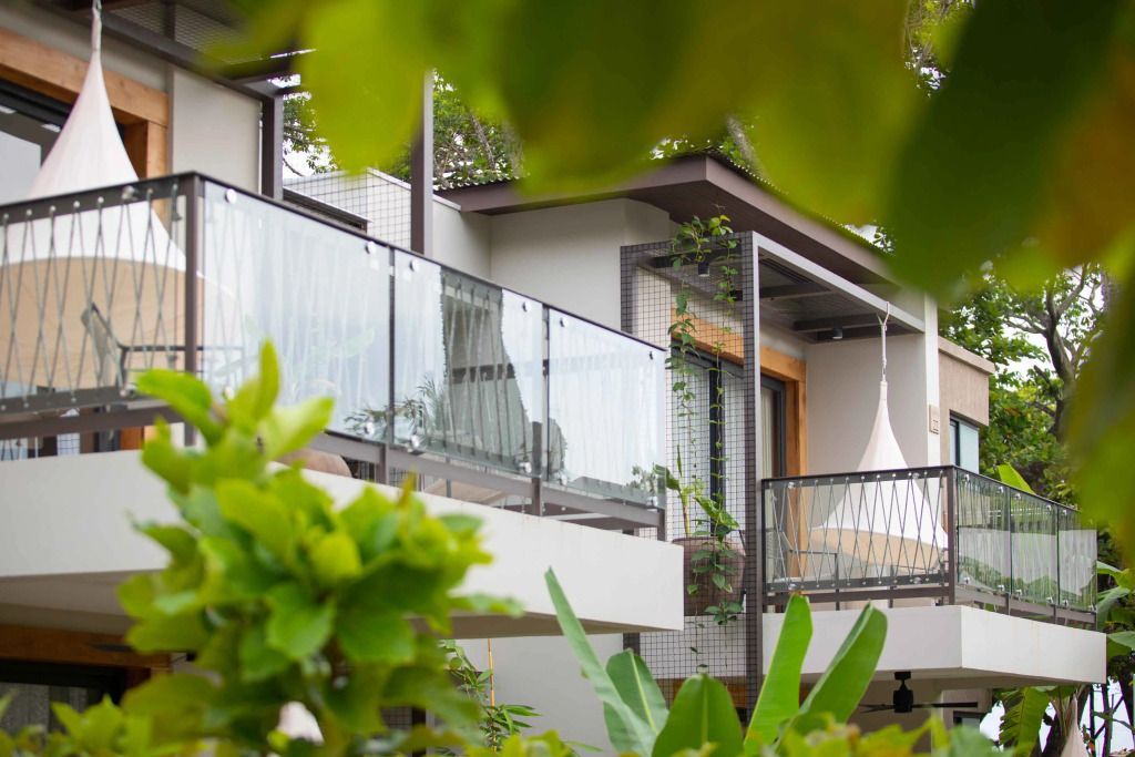 Balkon mit Glasgeländer in grüner Umgebung