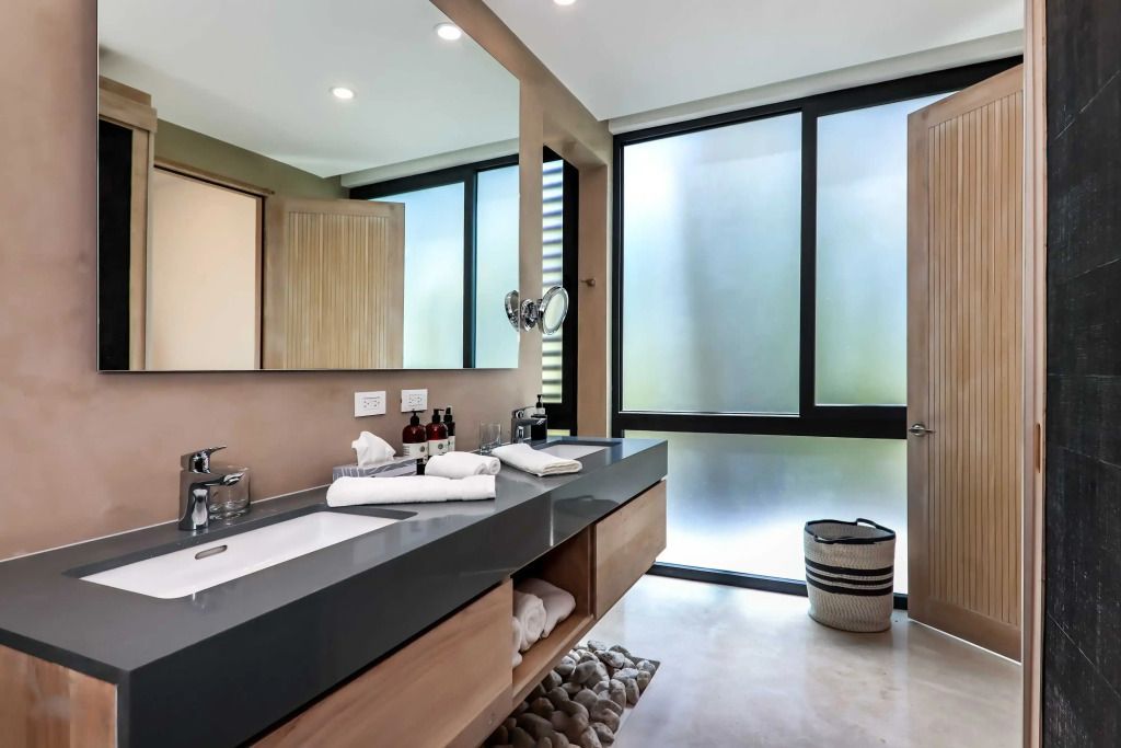 Modernes Badezimmer mit Doppelwaschbecken und großen Fenstern.