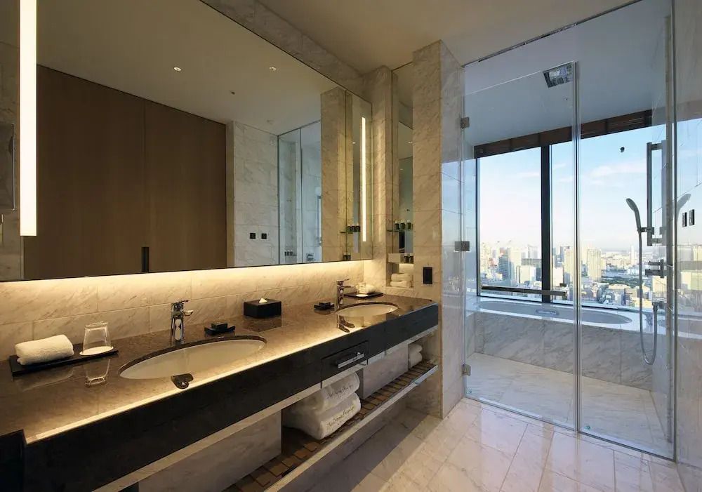 Modernes Badezimmer mit Doppelwaschbecken und Blick auf die Stadt