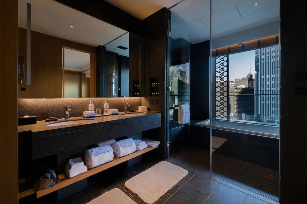 Helles Badezimmer mit Badewanne und Ausblick auf die Stadt