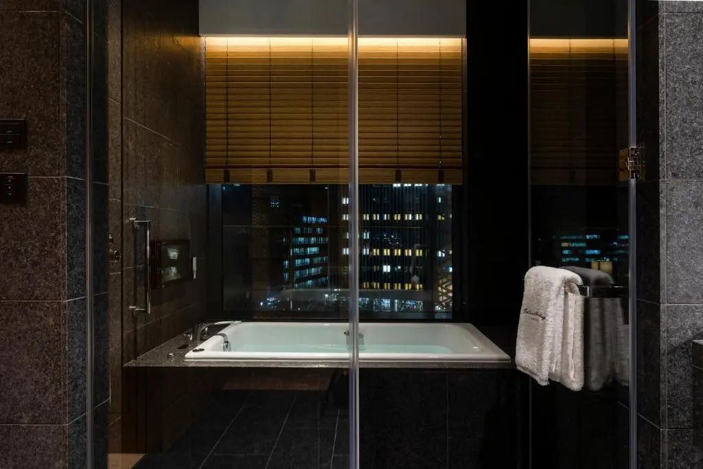 Abendlicher Ausblick aus dem Badezimmer mit moderner Badewanne