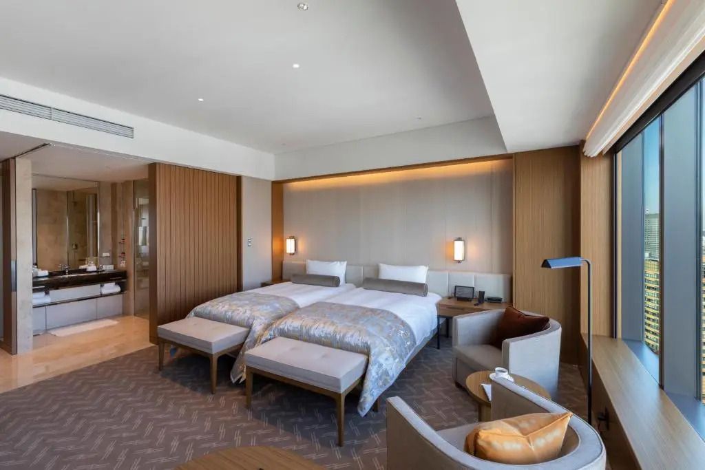 Helles Prestige Zimmer mit zwei Einzelbetten, einem Sofa und modernem Design.