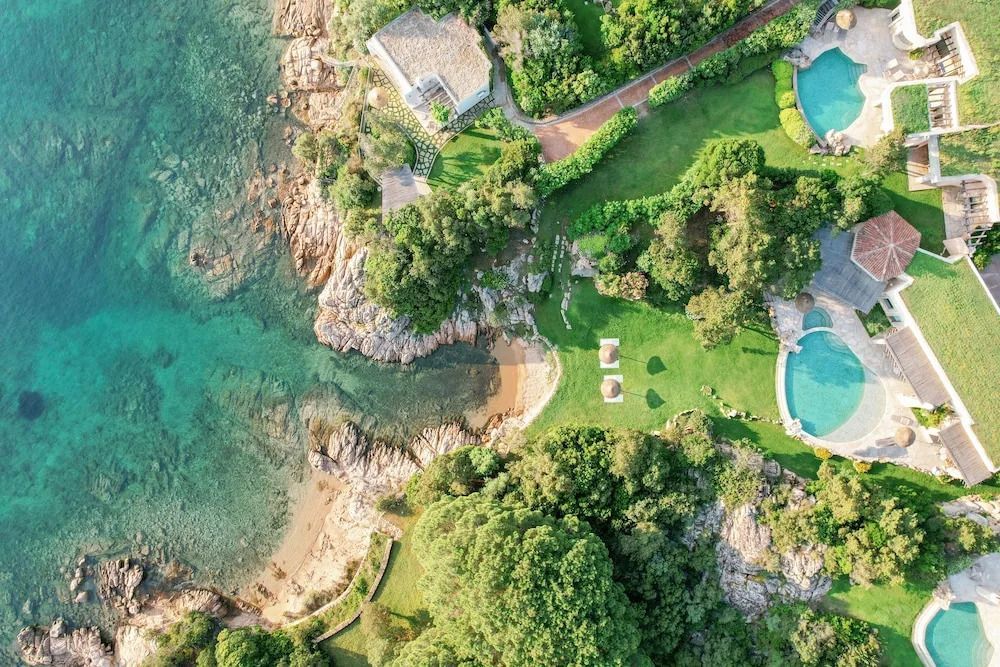 Luftaufnahme der Villa und Küstenlandschaft mit strahlend blauem Wasser