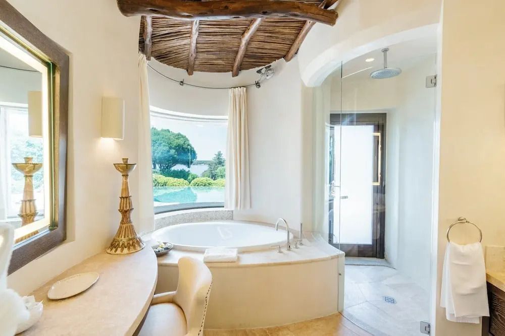 Luxuriöser Badbereich mit Whirlpool und Blick auf den privaten Pool