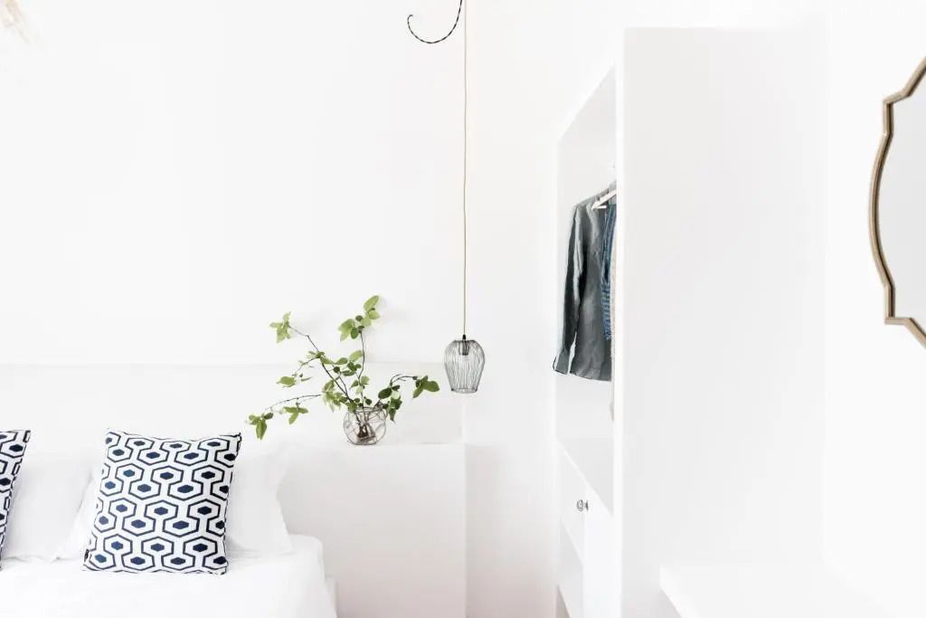 Minimalistisch eingerichtetes Zimmer mit weißen Möbeln und Pflanzen