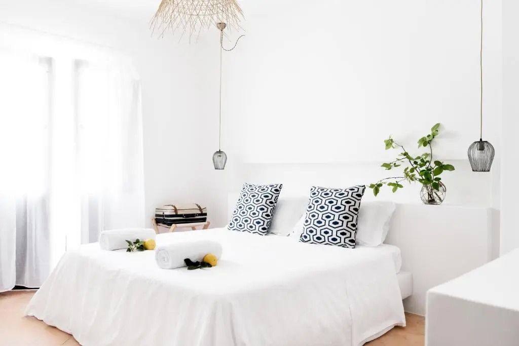 Helles Zimmer mit Doppelbett und dekorativen Kissen