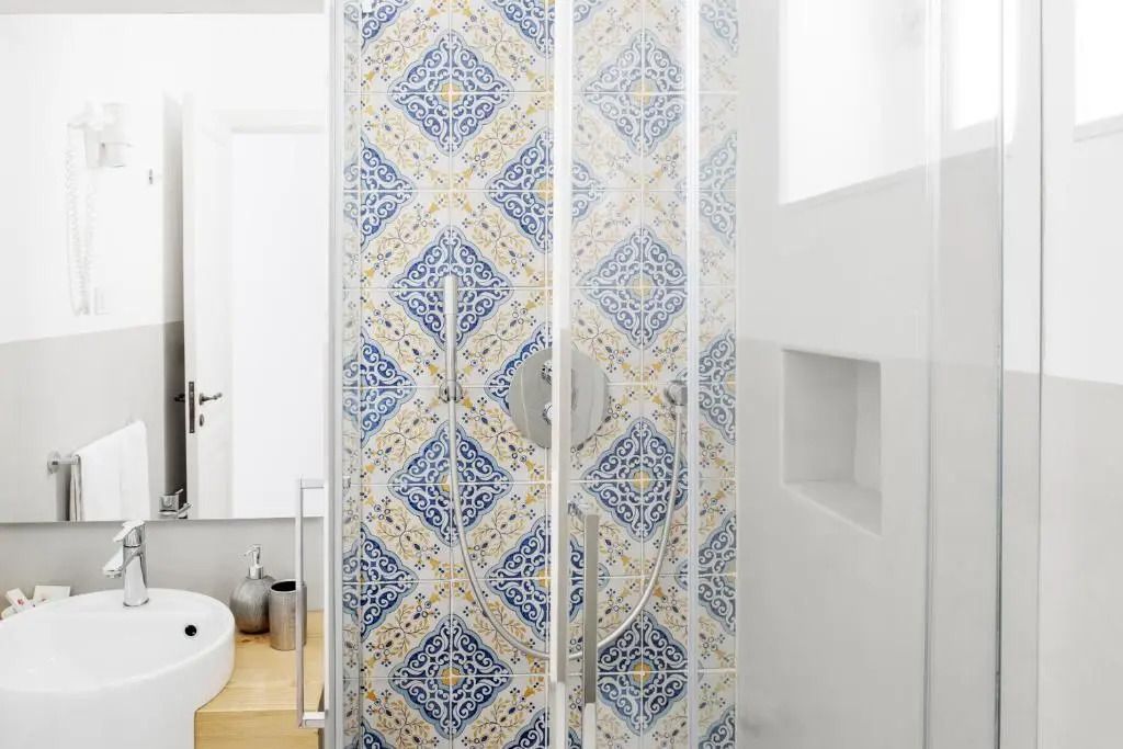 Dusche im Standard Doppel Zimmer mit kunstvollen Fliesen und Glaswand