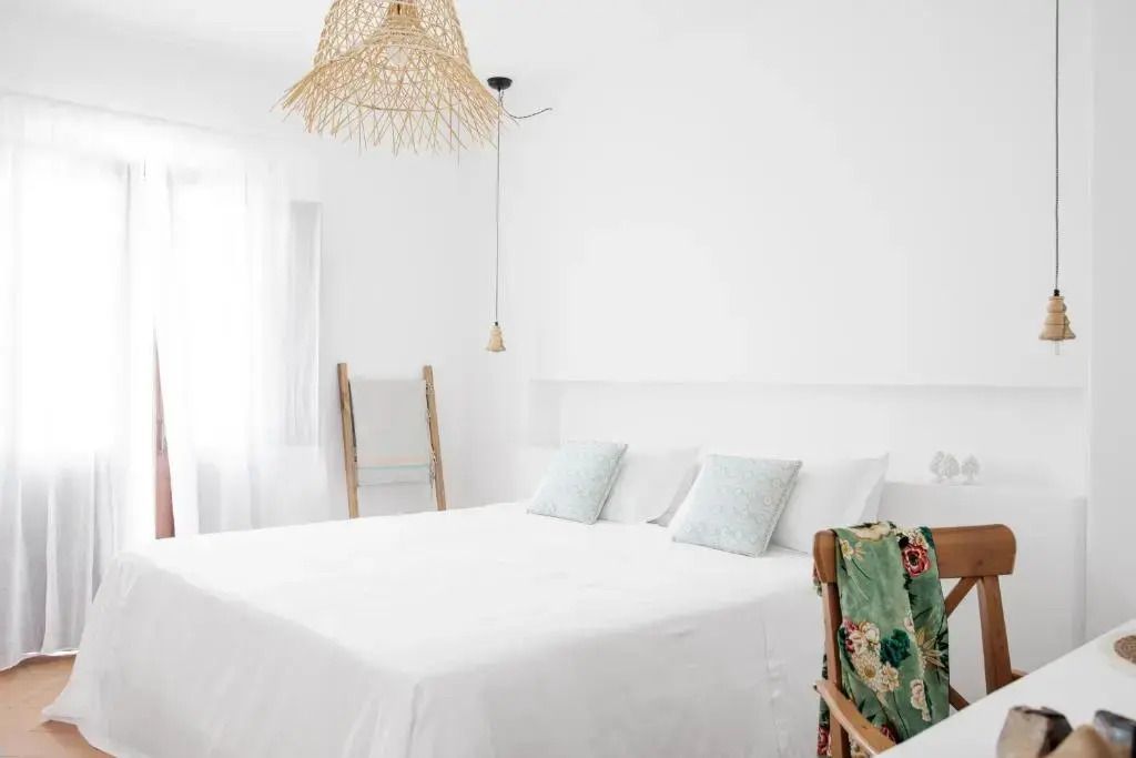 Standard Doppelzimmer mit Gartenblick und Bett mit weißen Laken