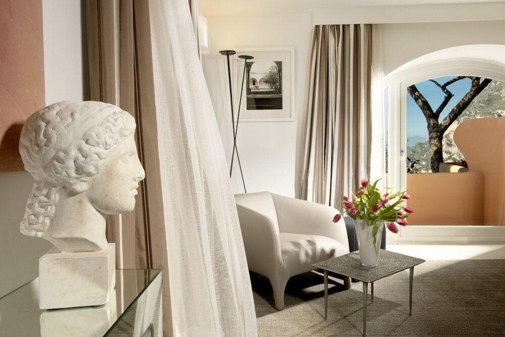 Elegantes Zimmer mit Sessel und Kunstwerk Blick auf Meer vom Balkon