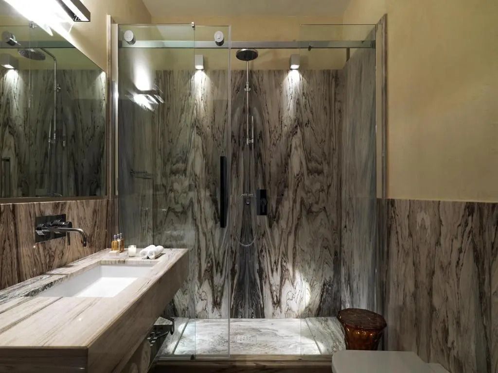 Luxuriöses Badezimmer mit großer Duschkabine in Marmoroptik im Punta Tragara Hotel