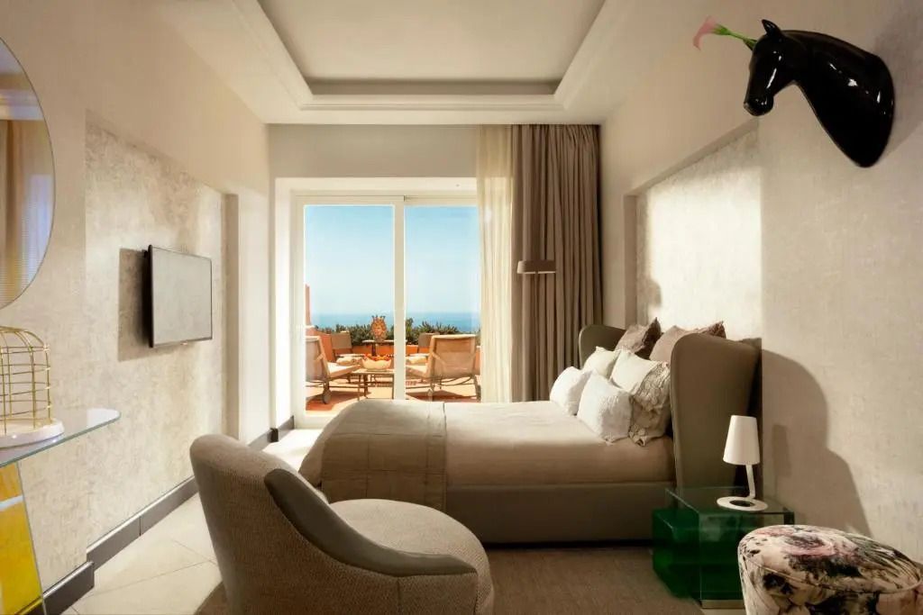 Luxuriöses Schlafzimmer mit direktem Zugang zur Terrasse und Meerblick im Punta Tragara Hotel
