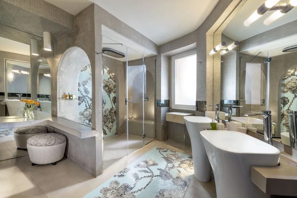 Modernes Bad mit stilvoller Dusche und großem Spiegel in Suite