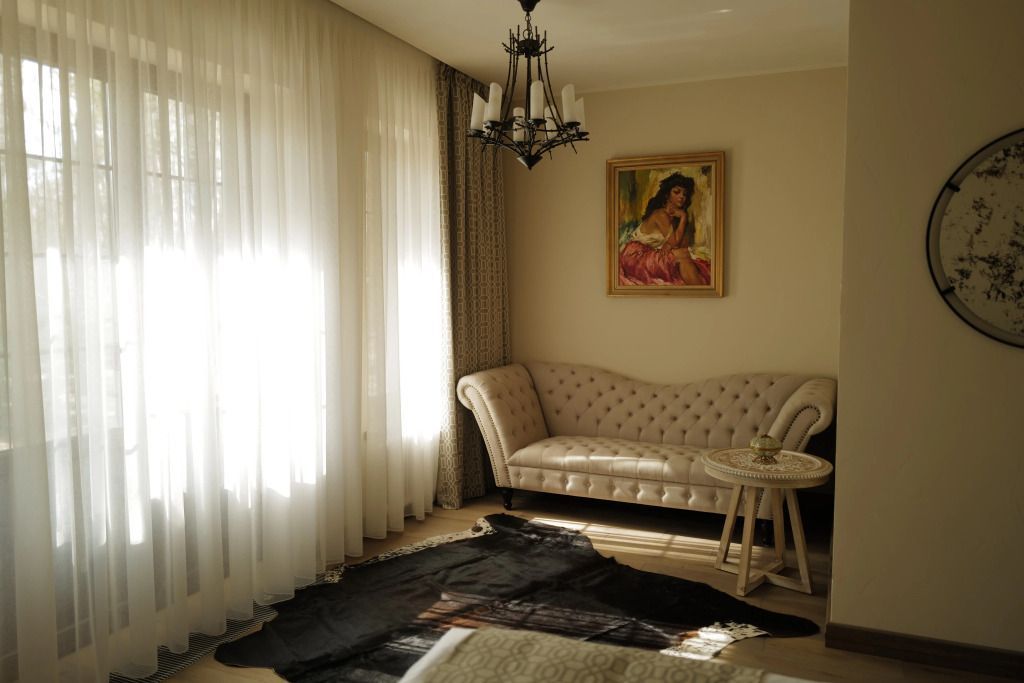 Eleganter Sitzbereich mit Sofa und Gemälde im Deluxe Strasbourg Zimmer