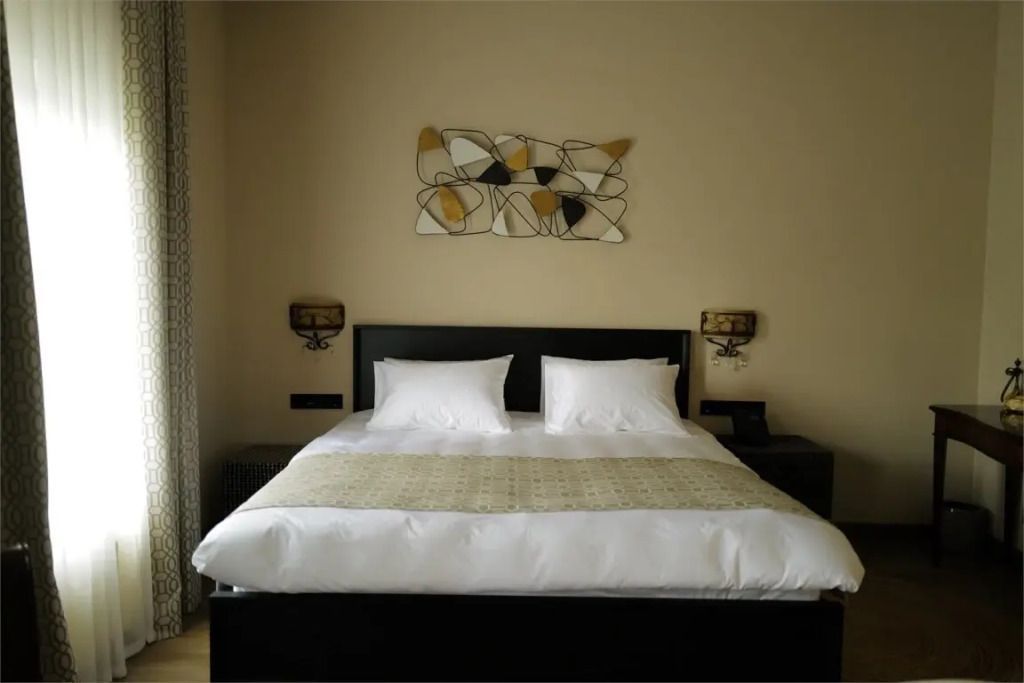 Elegantes Doppelbett in stilvoller Suite mit moderner Kunst an der Wand