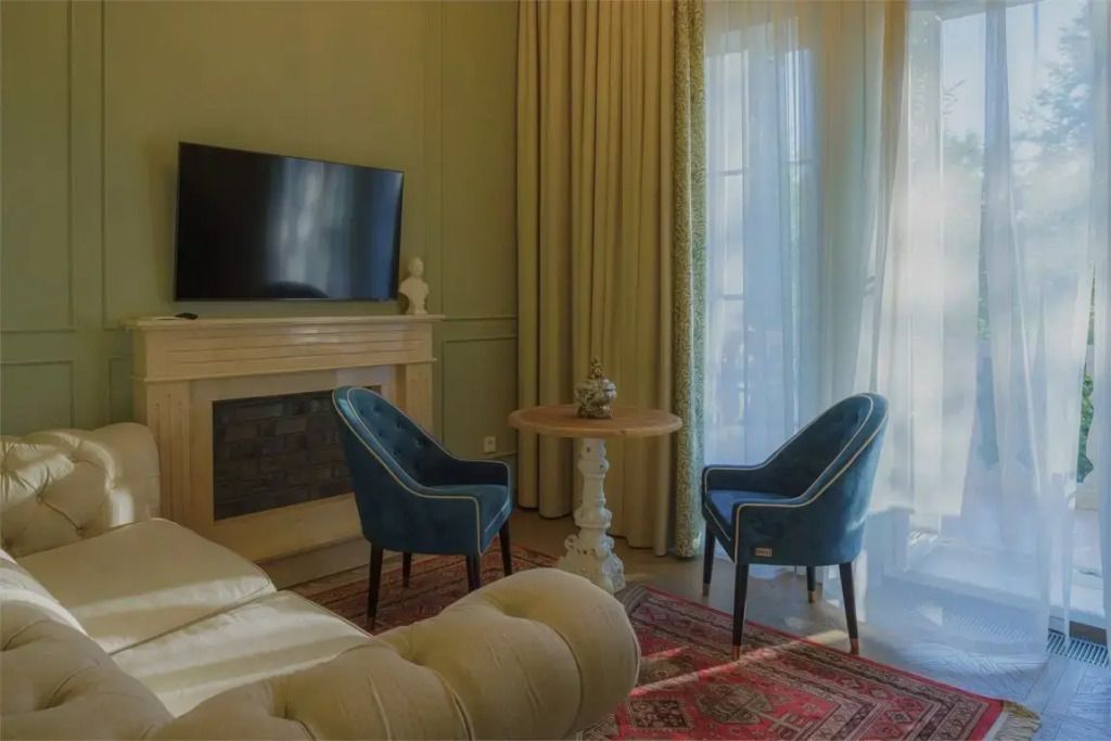 Gemütliche Sitzecke mit blauen Sesseln und großem Fernseher