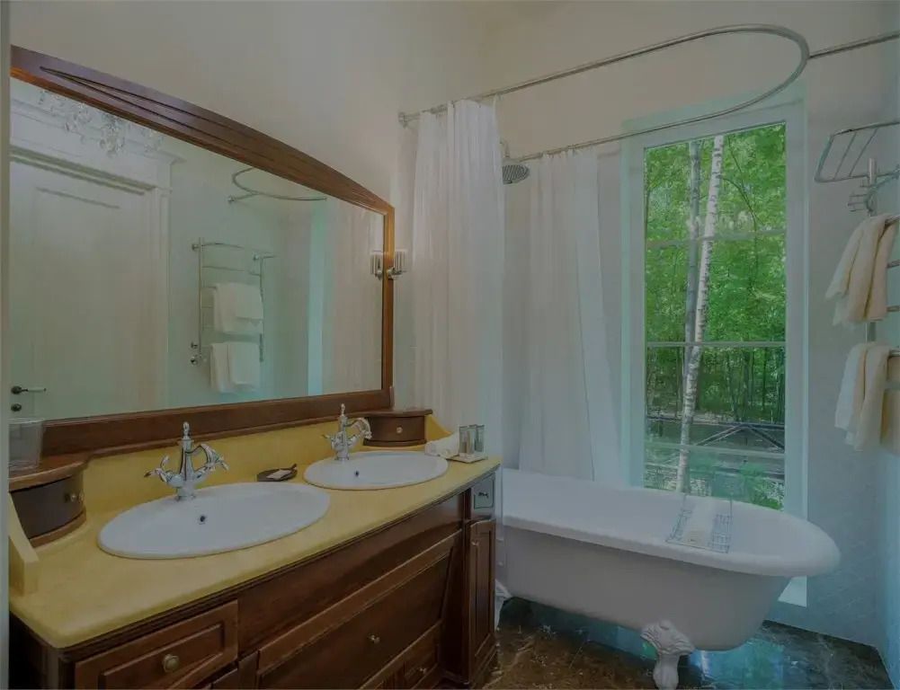 Geräumiges Badezimmer mit freistehender Badewanne und Doppelwaschbecken