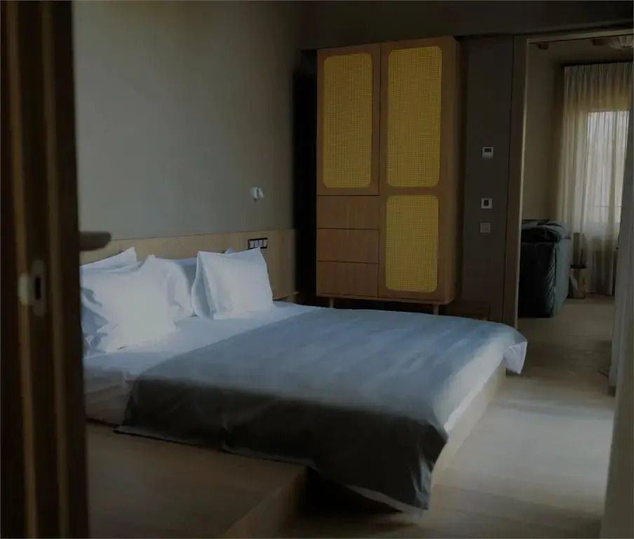 Doppelbett mit hochwertiger Bettwäsche und dekorativem Schrank