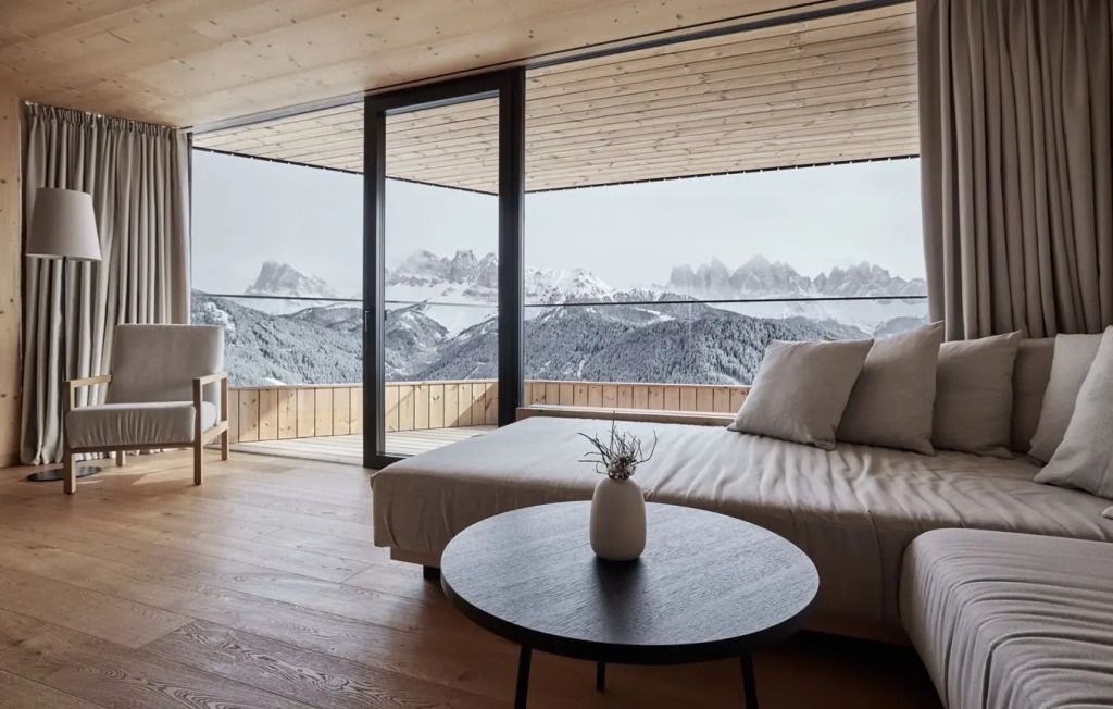 Modernes Schlafzimmer mit Panoramablick auf die Dolomiten durch große Fenster