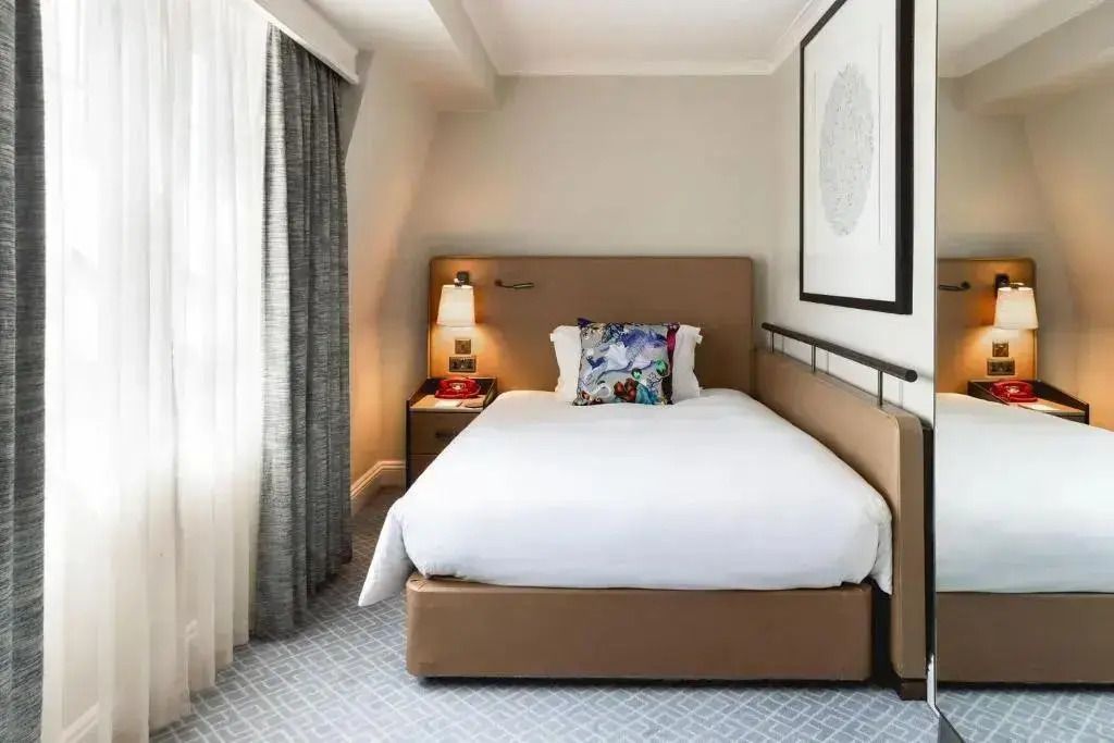 Gemütliches Doppelzimmer mit modernem Design und großem Fenster im Kimpton Fitzroy London