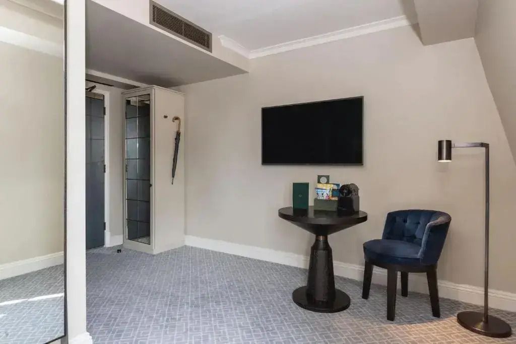 Sitzecke mit Tisch und Fernseher im modernen Hotelzimmer