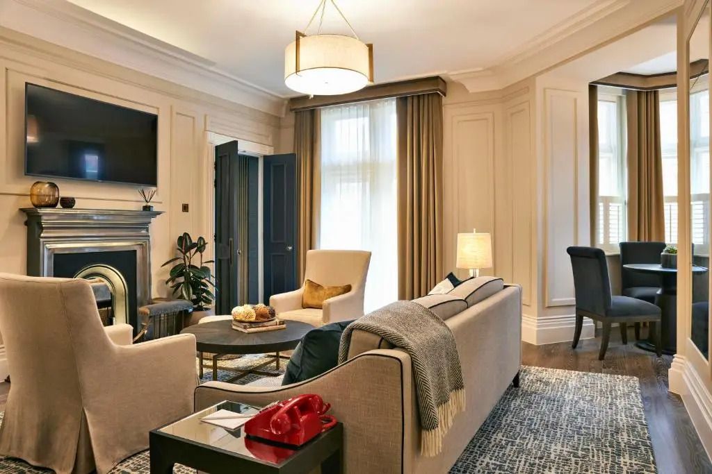 Schicke Sitzecke mit Sofa, Sessel und modernem Dekor in hellen Farben.