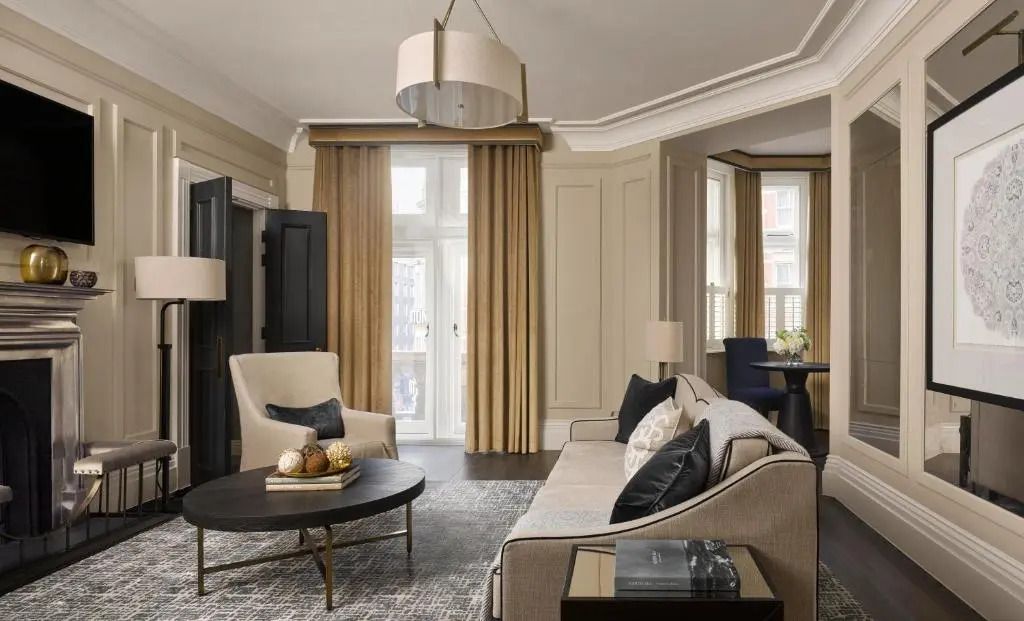 Großer, lichtdurchfluteter Wohnraum mit eleganten Sitzgelegenheiten und klassischen Details.