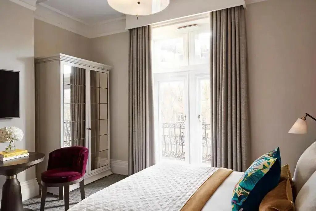 Elegantes Doppelzimmer mit großem Fenster und stilvoller Einrichtung