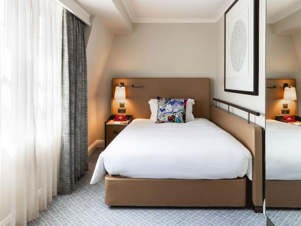 Behagliches Zimmer mit großem Fenster und luxuriösem Bett für zwei Personen