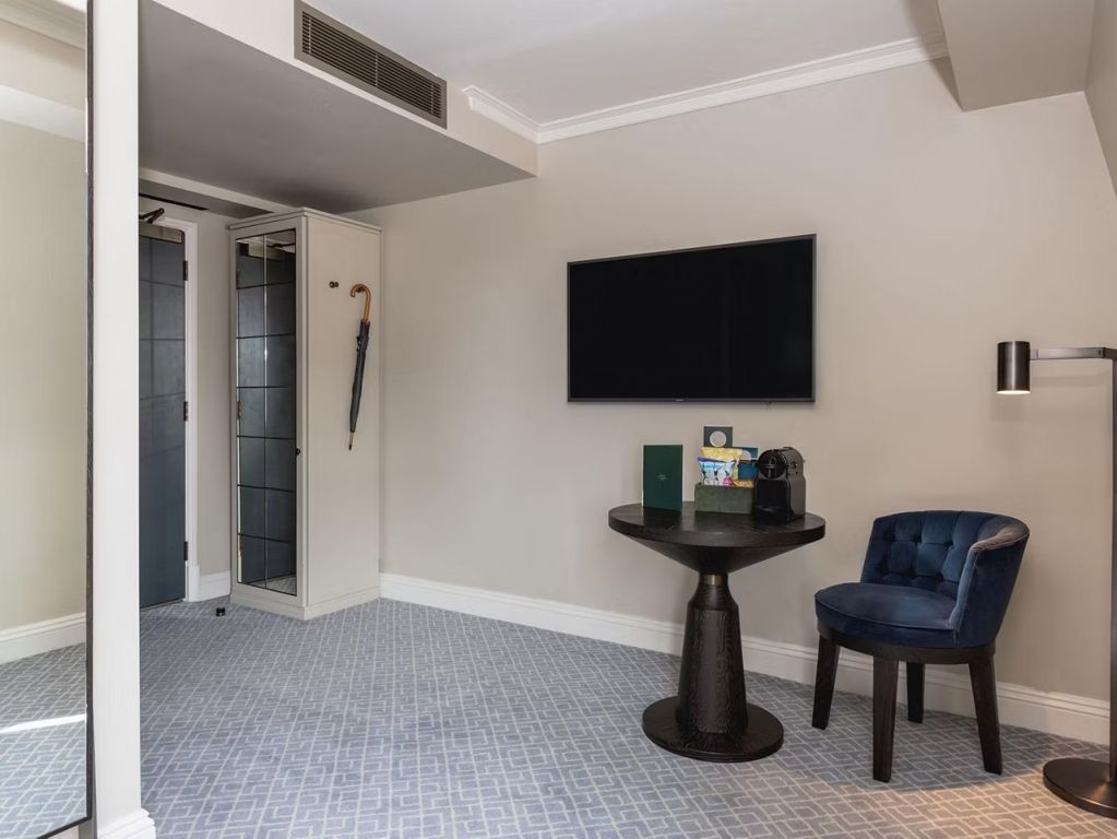 Modernes Zimmer mit Flachbild-TV und gemütlicher Sitzecke in ruhigen Farben