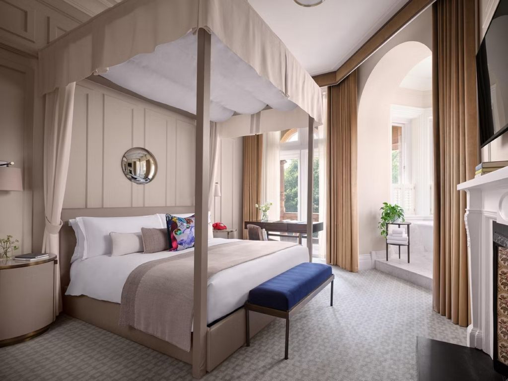 Helles Schlafzimmer mit Himmelbett und großen Fenstern in der Bloomsbury Suite