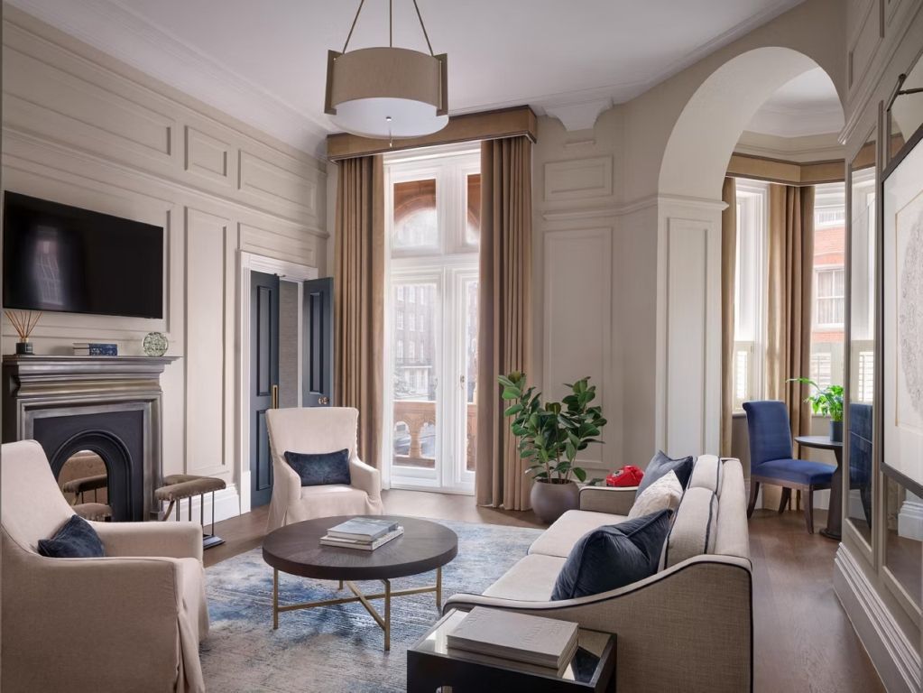 Geräumiger Wohnraum mit bequemer Sitzecke und eleganten Vorhängen in der Suite