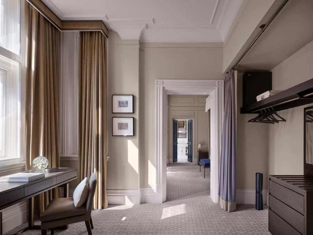 Helles, elegantes Zimmer mit Schreibtisch und klassischer Architektur im Kimpton Fitzroy London.