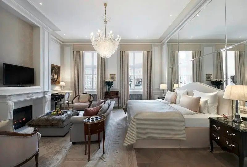 Großzügige Junior-Suite mit Doppelbett, Spiegelwand und luxuriösem Kronleuchter