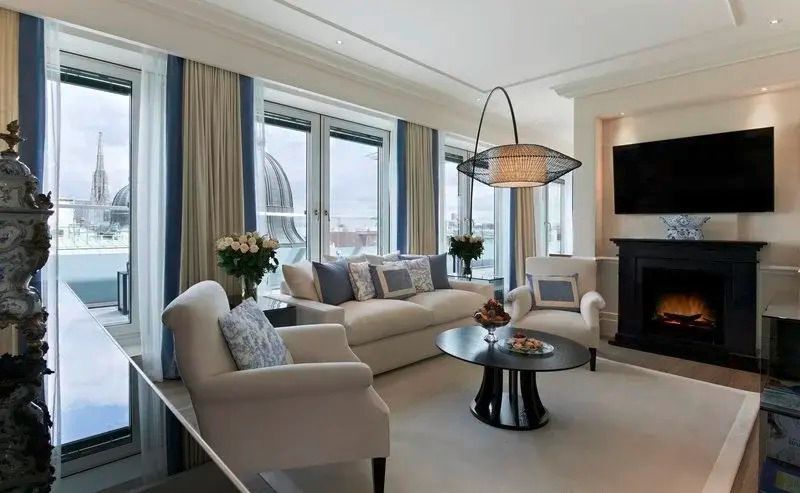Helles Wohnzimmer mit Sofas, großem Fenster und urbanem Ausblick