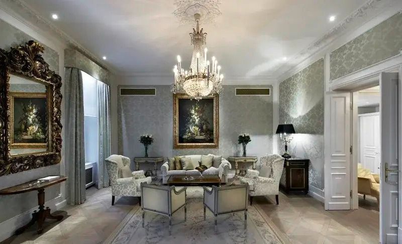Eleganter Raum mit Kronleuchter, klassischen Sesseln und Gemälde